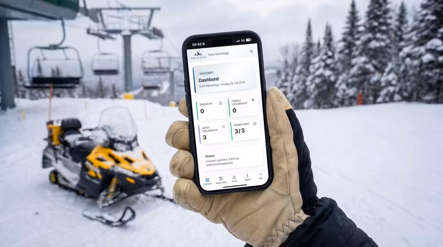 Driftsleder sjekker MountainControl-appen på telefonen ute i skianlegget
